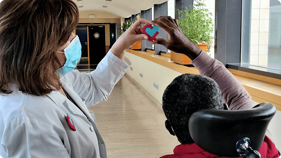Profesional sanitaria y paciente forman un corazón con las manos